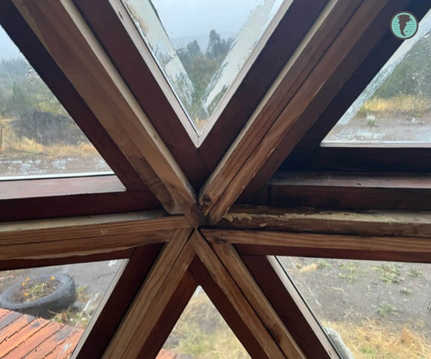 Encuentro interior de aberturas triangulares con signos de filtración entre marco y estructura del domo